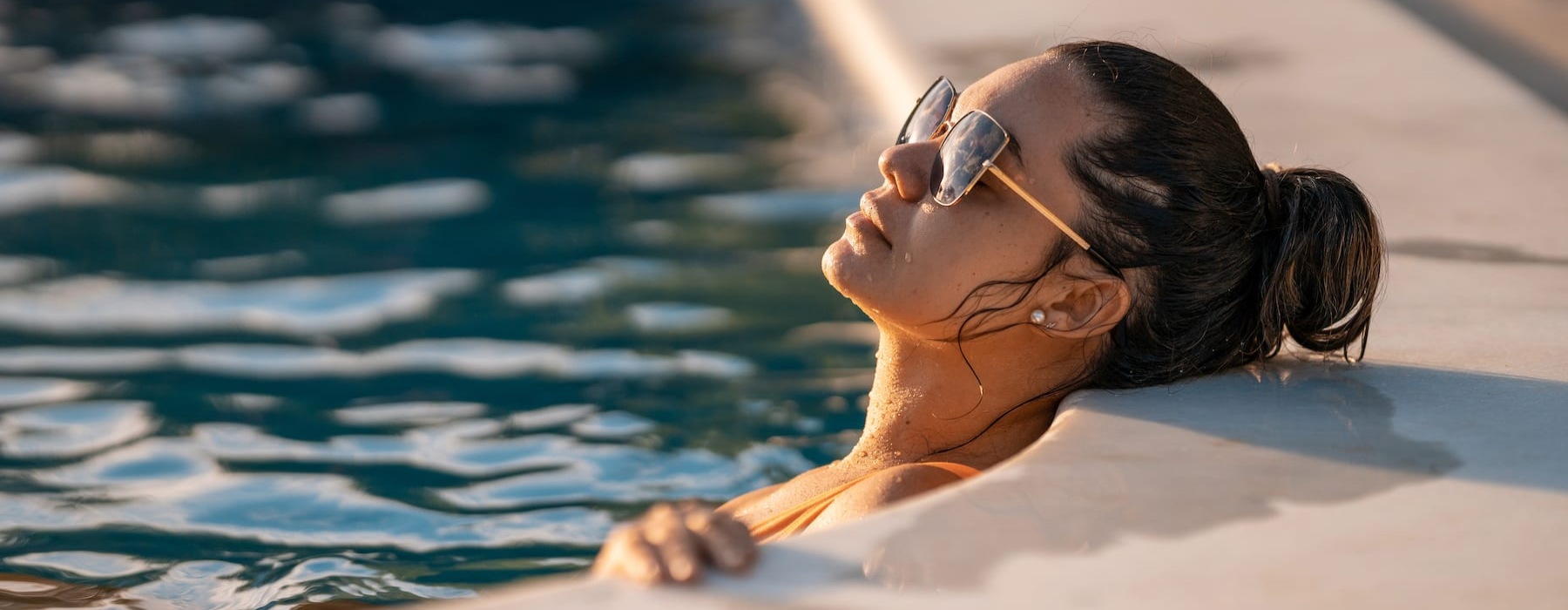 lifestyle image of a woman laying in a bright pool